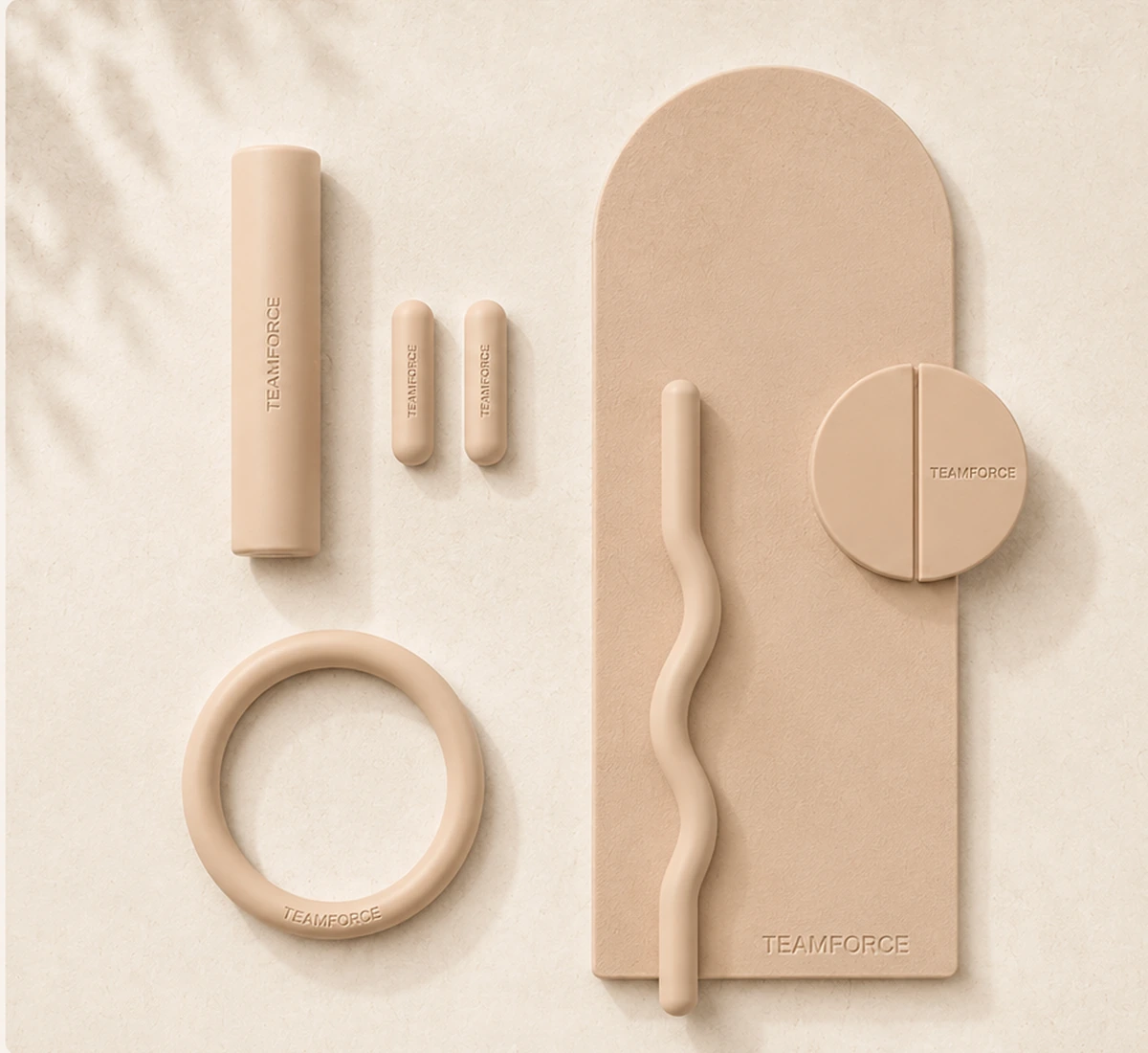 Beige silicone Pilates accessories arranged exactly as a premium soft-touch collection flat lay.